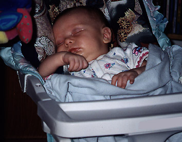 small infant positioned in a swing using a Travelbud